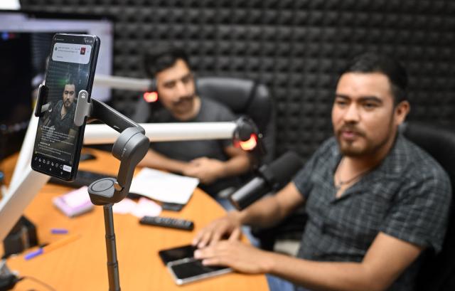 Broadcasters from San Bartolo University Radio, part of the Autonomous University of the State of Hidalgo, transmit messages and information to residents affected by recent rains in communities surrounding San Bartolo Tutotepec, Hidalgo state, Mexico, on October 13, 2025. The death toll from flooding in central and eastern Mexico -mostly in the Veracruz, Hidalgo and Puebla states- has risen sharply to at least 64, with another 65 still missing, authorities reported. (Photo by Alfredo ESTRELLA / AFP)