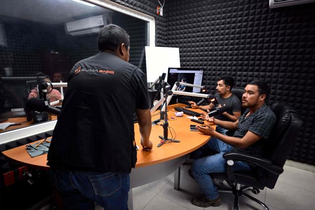Broadcasters from San Bartolo University Radio, part of the Autonomous University of the State of Hidalgo, transmit messages and information to residents affected by recent rains in communities surrounding San Bartolo Tutotepec, Hidalgo state, Mexico, on October 13, 2025. The death toll from flooding in central and eastern Mexico -mostly in the Veracruz, Hidalgo and Puebla states- has risen sharply to at least 64, with another 65 still missing, authorities reported. (Photo by Alfredo ESTRELLA / AFP)