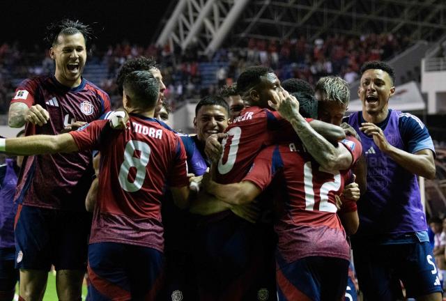 Costa Rica's forward #12 Alonso Martinez celebrates with teammates after scoring a goal during the 2026 FIFA World Cup Concacaf qualifier football match between Costa Rica and Nicaragua at the National Stadium in San Jose on October 13, 2025. (Photo by EZEQUIEL BECERRA / AFP)