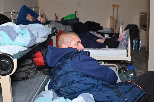 Hospital patients sit in a bomb shelter under one of the hospital buildings following Russian strikes in Kharkiv, on October 13, 2025, amid the Russian invasion of Ukraine. (Photo by SERGEY BOBOK / AFP)