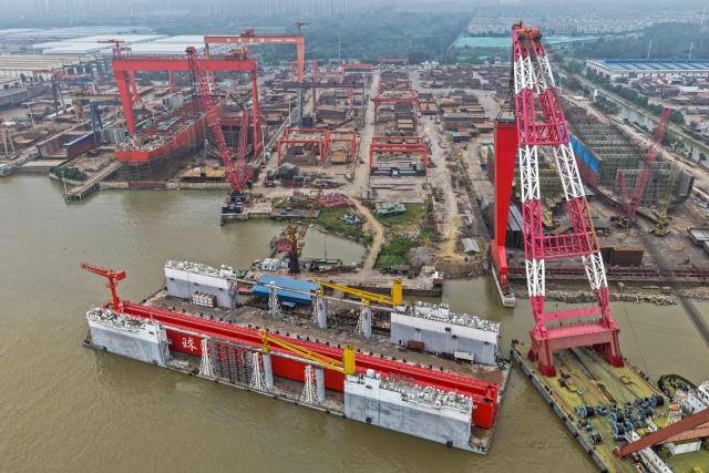 This aerial view shows ships under construction at a shipbuilding facility along the Yangtze River in Yangzhou, east China's Jiangsu province, on October 14, 2025. (Photo by -STR / AFP) / China OUT
