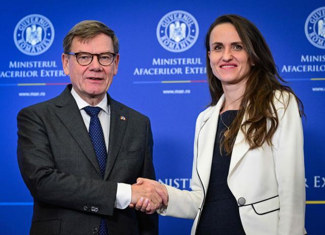 Romanian Foreign Minister Oana Toiu (R) and German Foreign Minister Johann Wadephul shake hands as they meet at the Romanian Foreign Office in Bucharest, Romania, on October 14, 2025. (Photo by Daniel MIHAILESCU / AFP)