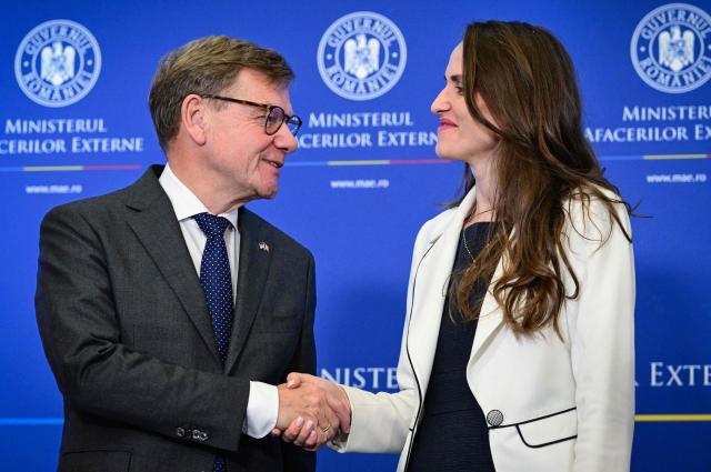 Romanian Foreign Minister Oana Toiu (R) and German Foreign Minister Johann Wadephul shake hands as they meet at the Romanian Foreign Office in Bucharest, Romania, on October 14, 2025. (Photo by Daniel MIHAILESCU / AFP)