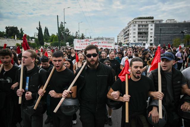Protestors shout slogans as they take part in a demonstration during a 24-hour strike against government plans introducing an optional 13-hour workday, in Athens on October 14, 2025. Transport and services in Greece were disrupted on October 14, 2025 for the second time this month as the mobilisation will shut down public and municipal services and paralyse ferries and trains, but flights are unaffected. (Photo by Aris MESSINIS / AFP)