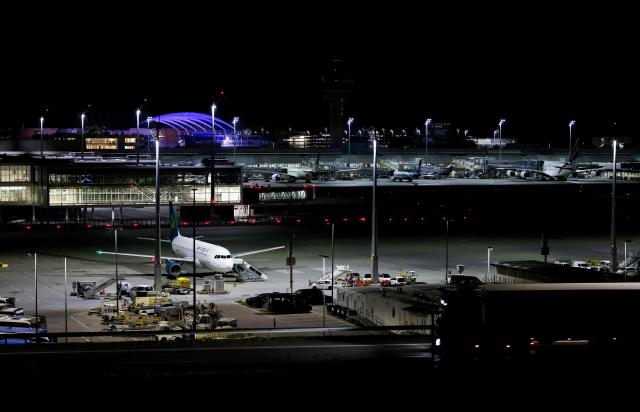 (FILES) Night view shows an Airlingus plane grounded at Munich International Airport in Munich, southern Germany, on early October 4, 2025, after reports of drone sightings again forced Munich airport to close and more than 30 flights had to be cancelled and left nearly 3,000 passengers stranded. Once holidaymakers took off from here, but today an ex-Soviet airfield is a testing ground for ways to take down the drones increasingly buzzing through German skies. Germany has been rattled by a spate of mysterious sightings of unmanned aerial vehicles (UAVs), believed to be from Russia, over military bases, industrial sites and an airport. But at the airstrip near the eastern city of Magdeburg, researchers of the German Aerospace Center (DLR) have been testing more subtle options to deal with potentially hostile drones. (Photo by Michaela STACHE / AFP)