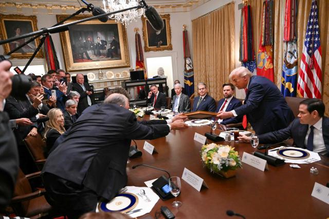 US President Donald Trump (2nd-R) receives a framed letter presented by Argentina's President Javier Milei in the Cabinet Room at the White House in Washington, DC on October 14, 2025. (Photo by ANDREW CABALLERO-REYNOLDS / AFP)