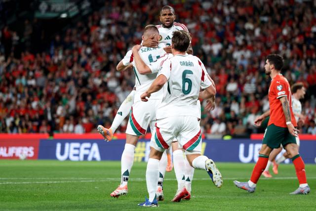 Hungary's defender #04 Attila Szalai celebrates with his teammates after scoring the opening goal during the 2026 World Cup qualifiers Europe zone group F football match between Portugal and Hungary at Jose Alvalade stadium in Lisbon on October 14, 2025. (Photo by PATRICIA DE MELO MOREIRA / AFP)