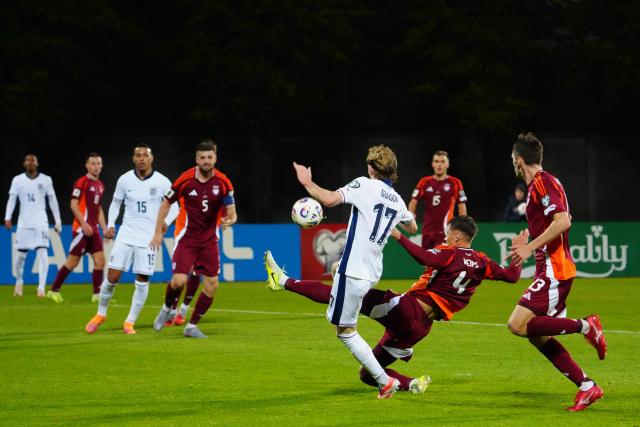 England's midfielder #17 Anthony Gordon (C) is tackled by Latvia's defender #04 Roberts Veips during the 2026 World Cup qualifying group K football match between Latvia and England at the Daugava Stadium in Riga, Latvia on October 14, 2025, (Photo by Gints Ivuskans / AFP)