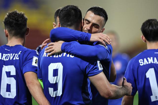 Serbia's forward #09 Aleksandar Mitrovic (CR) celebrates with Serbia's midfielder #11 Filip Kostic (CL) after scoring Serbia's third goal from the penalty spot during the FIFA World Cup 2026 Group K European qualification football match between Andorra and Serbia, at the New FAF Stadium in Encamp, on October 14, 2025. (Photo by Valentine CHAPUIS / AFP)