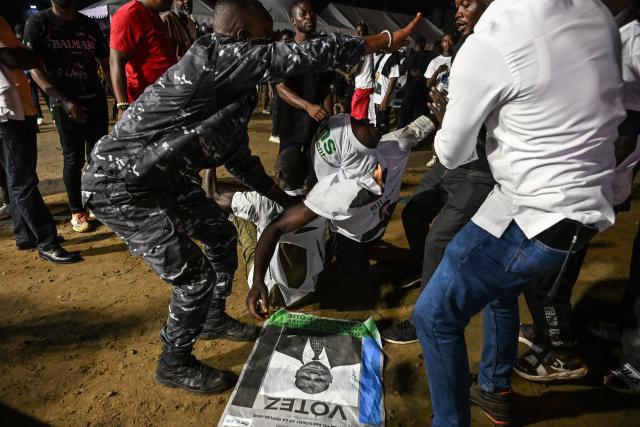 A An Ivorian police officer intervenes to calm supporters of Presidential Candidate for the Democratic Congress (CODE) Jean-Louis Billon, during his campaign rally in the commune of Cocody in Abidjan on October 14, 2025. Ivory Coast Presidential election is scheduled for October 25, 2025. (Photo by Sia KAMBOU / AFP)