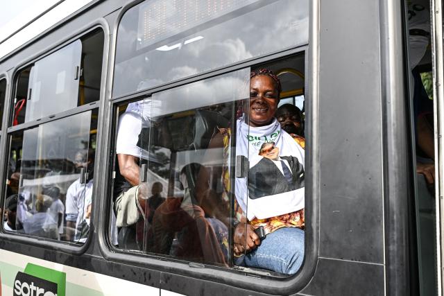 Supporters wearing T-shirts bearing the image of Democratic Congress (CODE) presidential candidate Jean-Loui Billon arrive in one of the buses for his campaign rally in the commune of Cocody in Abidjan on October 14, 2025. Ivory Coast Presidential election is scheduled for October 25, 2025. (Photo by Sia KAMBOU / AFP)