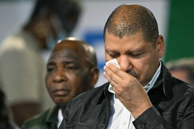 Presidential candidate for the Democratic Congress (CODE) Jean-Loui Billon cleans his face during his campaign rally in the commune of Cocody in Abidjan on October 14, 2025. Ivory Coast Presidential election is scheduled for October 25, 2025. (Photo by Sia KAMBOU / AFP)