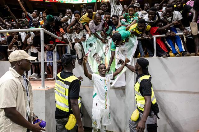 Senegal's forward #9 Cheikh Sabaly (C) celebrates with supporters his team’s victory at the end of the FIFA World Cup 2026 Africa qualifiers group B match between Senegal and Mauritania at Stade Abdoulaye Wade, in Diamniadio on October 14, 2025. (Photo by Patrick Meinhardt / AFP)