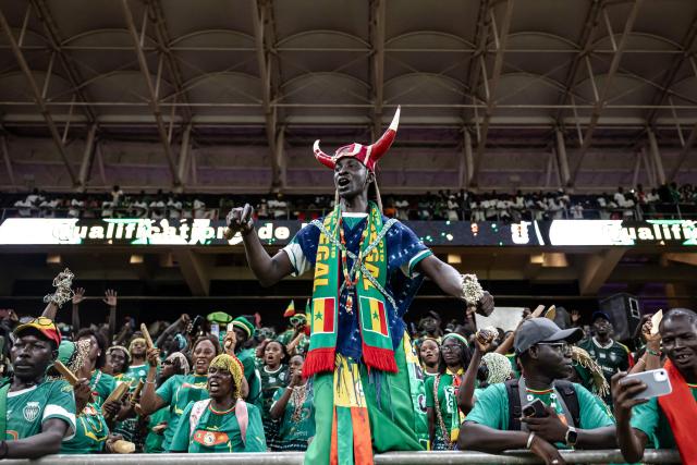 Senegal supporters celebrate their team’s victory at the end of the FIFA World Cup 2026 Africa qualifiers group B match between Senegal and Mauritania at Stade Abdoulaye Wade, in Diamniadio on October 14, 2025. (Photo by Patrick Meinhardt / AFP)