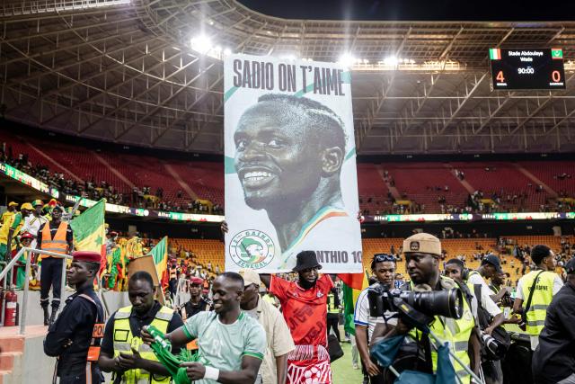 A Senegal supporter carries a billboard that reads “Sadio we love you” after Senegal’s victory at the end of the FIFA World Cup 2026 Africa qualifiers group B match between Senegal and Mauritania at Stade Abdoulaye Wade, in Diamniadio on October 14, 2025. (Photo by Patrick Meinhardt / AFP)