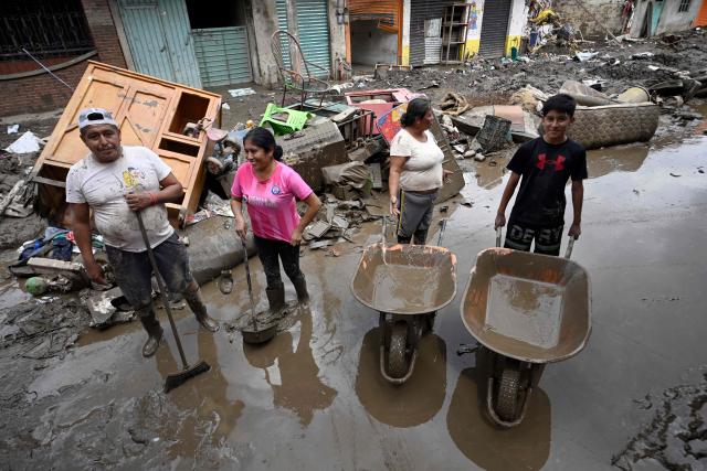 A family removes the mud after severe flooding hit the town of Huehuetla,, in Hidalgo state, Mexico on October 14, 2025. Rescuers scrambled on October 13, 2025, to reach people cut off by devastating floods that have claimed 64 lives in central and eastern Mexico, with another 65 people reported missing. (Photo by Alfredo ESTRELLA / AFP)