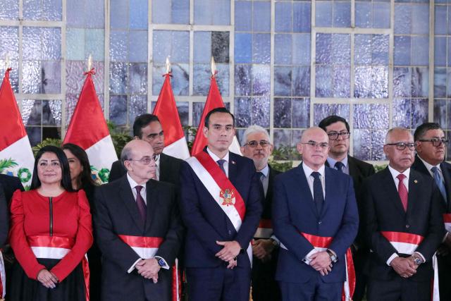 Peru's interim President Jose Jeri (C) poses for a family photo with his new ministers during the inauguration ceremony of his cabinet at the Presidential Palace in Lima on October 13, 2025. Peru's new interim president, José Jerí, appointed a retired general who fought against the Shining Path guerrilla group as interior minister on Tuesday, one of the key positions in the transitional government. (Photo by CONNIE FRANCE / AFP)