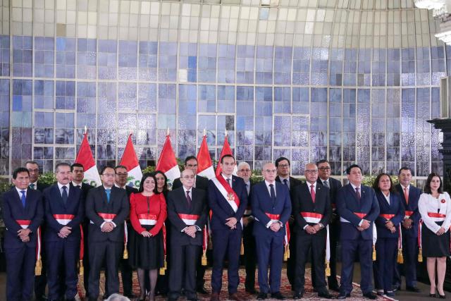 TOPSHOT - Peru's interim President Jose Jeri (C) poses for a family photo with his new ministers during the inauguration ceremony of his cabinet at the Presidential Palace in Lima on October 13, 2025. Peru's new interim president, José Jerí, appointed a retired general who fought against the Shining Path guerrilla group as interior minister on Tuesday, one of the key positions in the transitional government. (Photo by CONNIE FRANCE / AFP)