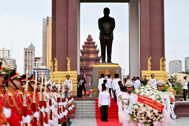 Cambodian government officials pay their respects in front of the monument of the late king Norodom Sihanouk during a ceremony commemorating his thirteenth death anniversary in Phnom Penh on October 15, 2025. (Photo by TANG CHHIN Sothy / AFP)