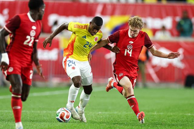 Colombia's defender #24 Andres Felipe Roman fights for the ball with Canada's forward #14 Jacob Shaffelburg during the international friendly football match between Canada and Colombia at Sports Illustrated Stadium in Harrison, New Jersey, on October 14, 2025. (Photo by CHARLY TRIBALLEAU / AFP)