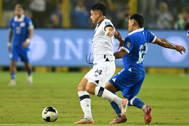Guatemala's forward #14 Darwin Lom and El Salvador's midfielder #12 Marcelo Diaz fight for the ball during the 2026 FIFA World Cup Concacaf qualifier football match between El Salvador and Guatemala at the Cuscatlan Stadium in San Salvador on October 14, 2025. (Photo by MARVIN RECINOS / AFP)