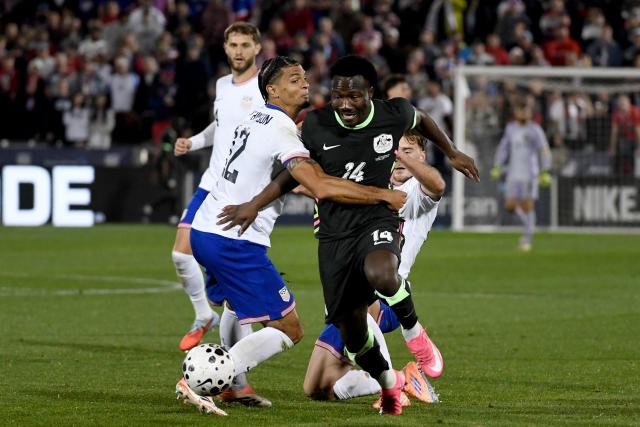 Australia's Tanzanian forward #14 Nestory Irankunda battles for control of the ball against USA’s defender #12 Miles Robinson during the international friendly football match between USA and Australia at Dick's Sporting Goods Park in Commerce City, Colorado, on October 14, 2025. (Photo by Jason Connolly / AFP)