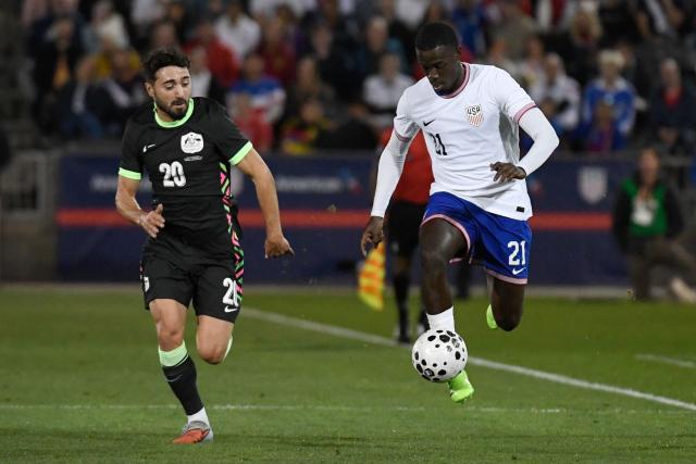USA’s #21 Tim Weah controls the ball against against Australia’s forward #20 Jacob Italiano during the international friendly football match between USA and Australia at Dick's Sporting Goods Park in Commerce City, Colorado, on October 14, 2025. (Photo by Jason Connolly / AFP)