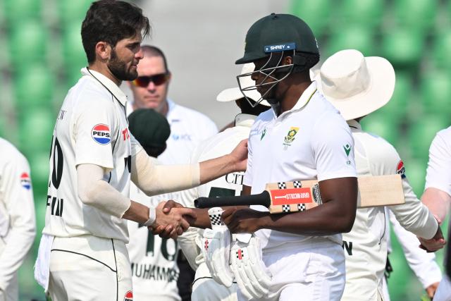 Pakistan's Shaheen Shah Afridi (L) shakes hands with South Africa's Kagiso Rabada after winning the first Test cricket match between Pakistan and South Africa at the Gaddafi Stadium in Lahore on October 15, 2025. (Photo by Aamir QURESHI / AFP)