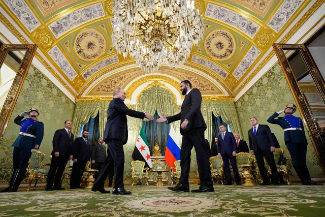 Russian President Vladimir Putin and Syrian interim president Ahmed al-Sharaa shake hands during their meeting at the Grand Kremlin Palace in Moscow on October 15, 2025. (Photo by Alexander Zemlianichenko / POOL / AFP)