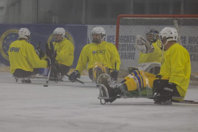 Team members, consisting of Ukrainian military veterans, athletes, and enthusiasts, participate in a para ice hockey training organized by the Ukrainian Para Ice Hockey Federation at the ATEK Ice Arena in Kyiv on October 15, 2025, amid the Russian invasion of Ukraine. Para hockey, or sledge hockey, is an adaptive form of hockey in which players—people with amputations or lower limb impairments—move across the ice on special sleds called sledges. Such training helps to build a community around inclusive sports, which promotes the rehabilitation and social adaptation of veterans, and is also a step towards creating a permanent national para hockey league and forming a Ukrainian national team for this sport. (Photo by Tetiana DZHAFAROVA / AFP)