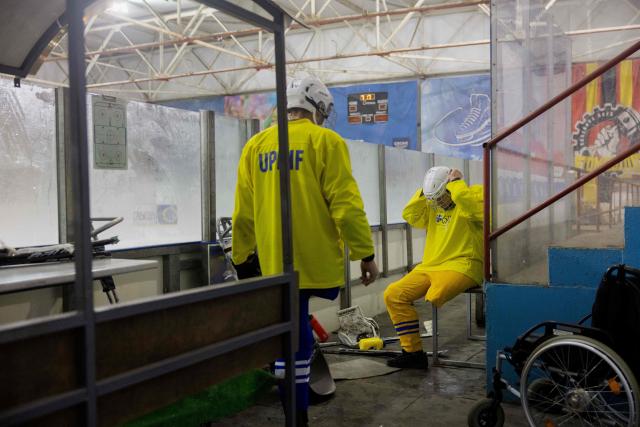 Team members, consisting of Ukrainian military veterans, athletes, and enthusiasts, prepare for a para ice hockey training organized by the Ukrainian Para Ice Hockey Federation at the ATEK Ice Arena in Kyiv on October 15, 2025, amid the Russian invasion of Ukraine. Para hockey, or sledge hockey, is an adaptive form of hockey in which players—people with amputations or lower limb impairments—move across the ice on special sleds called sledges. Such training helps to build a community around inclusive sports, which promotes the rehabilitation and social adaptation of veterans, and is also a step towards creating a permanent national para hockey league and forming a Ukrainian national team for this sport. (Photo by Tetiana DZHAFAROVA / AFP)