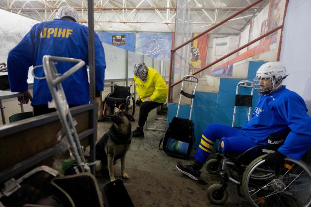 Team members, consisting of Ukrainian military veterans, athletes, and enthusiasts, prepare for a para ice hockey training organized by the Ukrainian Para Ice Hockey Federation at the ATEK Ice Arena in Kyiv on October 15, 2025, amid the Russian invasion of Ukraine. Para hockey, or sledge hockey, is an adaptive form of hockey in which players—people with amputations or lower limb impairments—move across the ice on special sleds called sledges. Such training helps to build a community around inclusive sports, which promotes the rehabilitation and social adaptation of veterans, and is also a step towards creating a permanent national para hockey league and forming a Ukrainian national team for this sport. (Photo by Tetiana DZHAFAROVA / AFP)