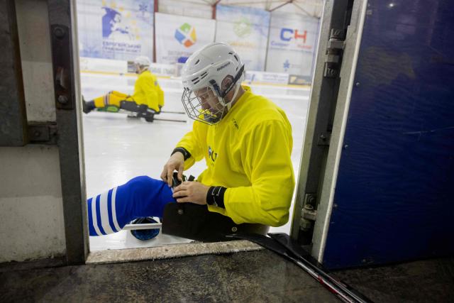 Team members, consisting of Ukrainian military veterans, athletes, and enthusiasts, prepare for a para ice hockey training organized by the Ukrainian Para Ice Hockey Federation at the ATEK Ice Arena in Kyiv on October 15, 2025, amid the Russian invasion of Ukraine. Para hockey, or sledge hockey, is an adaptive form of hockey in which players—people with amputations or lower limb impairments—move across the ice on special sleds called sledges. Such training helps to build a community around inclusive sports, which promotes the rehabilitation and social adaptation of veterans, and is also a step towards creating a permanent national para hockey league and forming a Ukrainian national team for this sport. (Photo by Tetiana DZHAFAROVA / AFP)