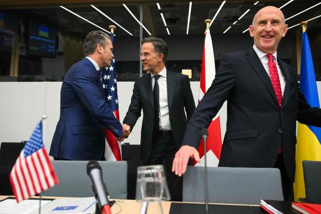 TOPSHOT - US Defense Secretary Pete Hegseth (L) shakes hands with NATO Secretary General Mark Rutte (C) as Britain's Defence Secretary John Healey looks on ahead of the start of the meeting of the Ukraine Defence Contact Group, part of the meeting of NATO Ministers of Defence Summit at the NATO headquarters in Brussels on October 15, 2025. (Photo by NICOLAS TUCAT / AFP)