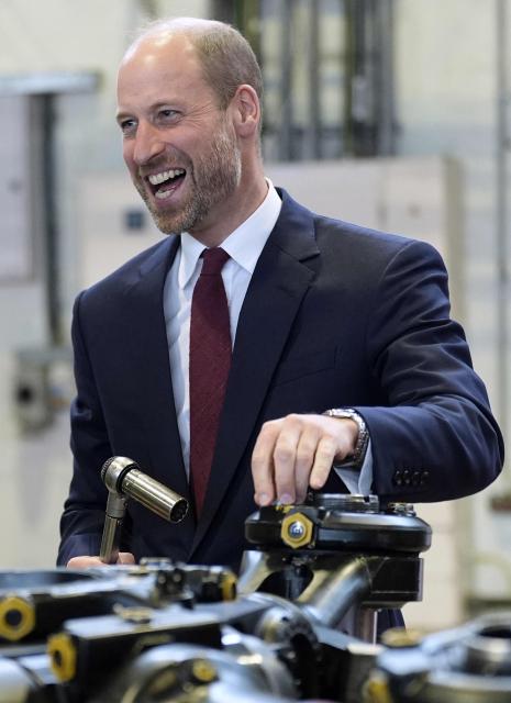 Britain's Prince William, Prince of Wales helps work on a main rotor head of a Chinook helicopter as he meets helicopter technicians from No. 28 (AC) Squadron, during a visit to RAF Benson in Wallingford, western England on October 15, 2025. (Photo by Andrew Matthews / POOL / AFP)
