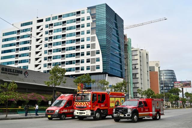 Guayaquil Fire Department vehicles remain at the site where a car bomb exploded the night before in front of a shopping center in northern Guayaquil, Ecuador, on October 15, 2025. One person died and several were injured after an explosion on Tuesday in a busy shopping area of the Ecuadorian port of Guayaquil, which was left in chaos, according to images released by local authorities. (Photo by MARCOS PIN / AFP)
