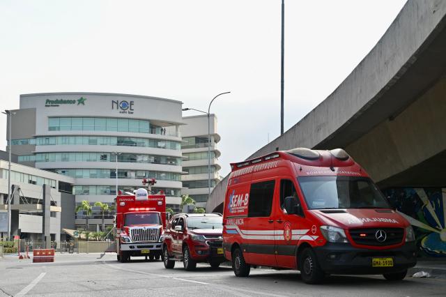 Guayaquil Fire Department vehicles remain at the site where a car bomb exploded the night before in front of a shopping center in northern Guayaquil, Ecuador, on October 15, 2025. One person died and several were injured after an explosion on Tuesday in a busy shopping area of the Ecuadorian port of Guayaquil, which was left in chaos, according to images released by local authorities. (Photo by MARCOS PIN / AFP)