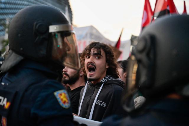 A protester shouts towards police during a demonstration against the participation of Israeli basketball team Hapoel IBI Tel-Aviv in the Euroleague, ahead of their match against Valencia Basket, in Valencia, on October 15, 2025. (Photo by Jose JORDAN / AFP)