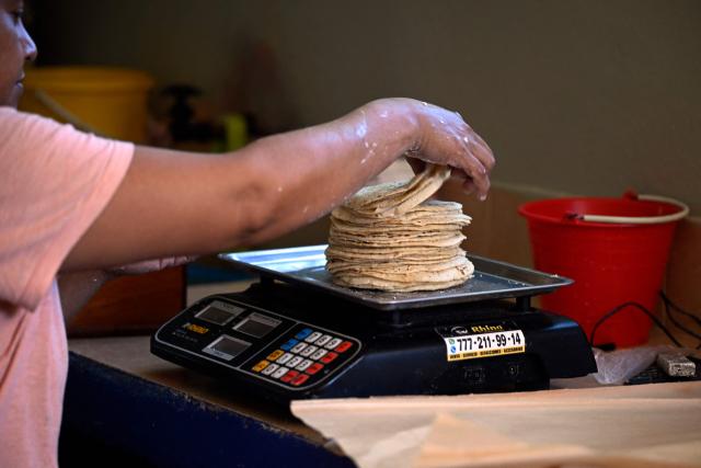 Dulce Esperanza Gomez sells tortillas in the town of San Bartolo Tutotepec, Hidalgo state, Mexico on October 15, 2025. In the towns of Mexico hit by last week's deadly rains, tortillas, which are vital to the Mexican diet, particularly in these impoverished areas, are beginning to run out. (Photo by Alfredo ESTRELLA / AFP)