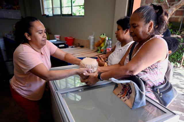 Dulce Esperanza Gomez sells tortillas in the town of San Bartolo Tutotepec, Hidalgo state, Mexico on October 15, 2025. In the towns of Mexico hit by last week's deadly rains, tortillas, which are vital to the Mexican diet, particularly in these impoverished areas, are beginning to run out. (Photo by Alfredo ESTRELLA / AFP)