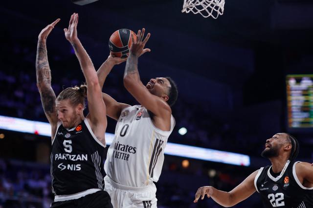 Real Madrid's Canadian forward #00 Trey Lyles goes up for a shot as Partizan Belgrade's US forward #5 Dylan Osetkowski defends during the Euroleague basketball match between Real Madrid Baloncesto and Partizan Belgrade at Movistar Arena in Madrid on October 15, 2025. (Photo by Oscar DEL POZO / AFP)