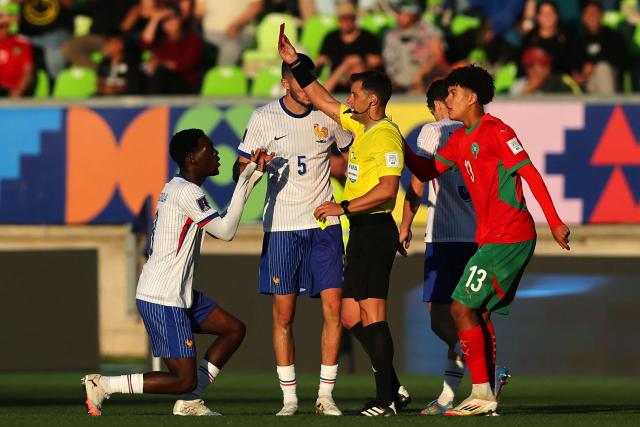Uruguayan referee Gustavo Tejera (C) gives a red card to France's midfielder #08 Rabby Nzingoula past Morocco's forward #13 Taha Majni during the 2025 FIFA U-20 World Cup semi-final football match between Morocco and France at the Elias Figueroa Stadium in Valparaiso, Chile on October 15, 2025. (Photo by Javier TORRES / AFP)