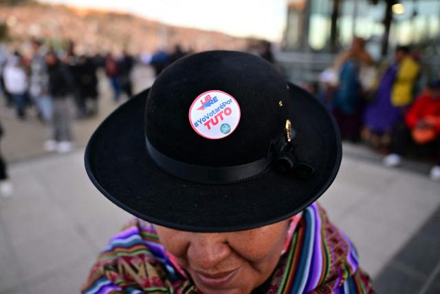 A supporter of Bolivia's presidential candidate for the Freedom and Democracy (Libre) Alliance, Jorge "Tuto" Quiroga, shows off a sticker on her hat ahead of his closing campaign rally in La Paz on October 15, 2025. An ex-president and a senator will go head-to-head in Bolivia's presidential runoff on October 19, 2025, both with promises to fix the South American country's broken economy. Senator Rodrigo Paz came from behind to take the top spot with 32 percent of votes cast in a first round in August, but has since fallen behind ex-president Jorge "Tuto" Quiroga in stated voter intention. (Photo by MARTIN BERNETTI / AFP)