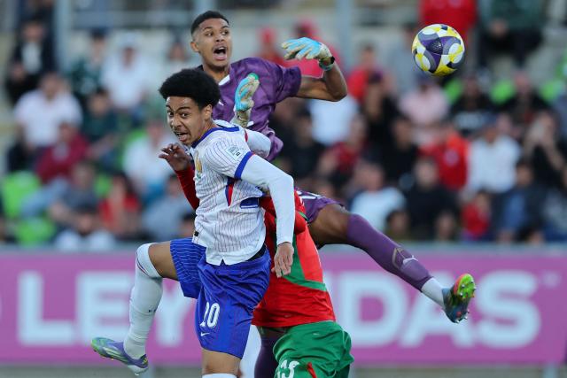 France's forward #20 Djylian N'Guessan and Morocco's goalkeeper #12 Ibrahim Gomis fight for the ball during the 2025 FIFA U-20 World Cup semi-final football match between Morocco and France at the Elias Figueroa Stadium in Valparaiso, Chile on October 15, 2025. (Photo by Javier TORRES / AFP)