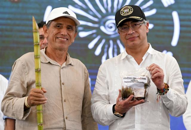 Colombia's President Gustavo Petro (R) poses for pictures with FARC dissidence commander Walter Mendoza during a ceremony to destroy war material in Puerto Asis, Colombia on October 15, 2025. Petro said on october 15, 2025, he would boycott an upcoming US-supported Summit of the Americas, deepening a rift with Washington -- which has already stripped him of a US visa. (Photo by David SALAZAR / AFP)