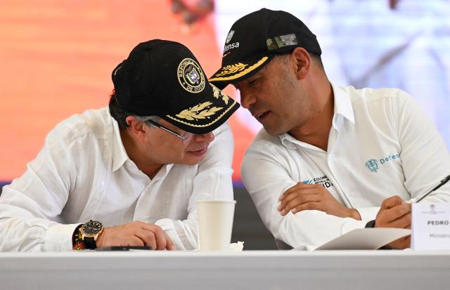 Colombia's President Gustavo Petro (L) chats with his Defense Minister Pedro Sanchez during a ceremony to destroy war material in Puerto Asis, Colombia on October 15, 2025. Petro said on october 15, 2025, he would boycott an upcoming US-supported Summit of the Americas, deepening a rift with Washington -- which has already stripped him of a US visa. (Photo by David SALAZAR / AFP)