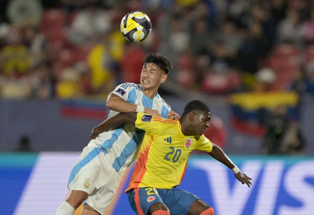 Argentina's defender #03 Julio Soler and Colombia's forward #20 Joel Canchimbo fight for the ball during the 2025 FIFA U-20 World Cup semi-final football match between Argentina and Colombia at the National Stadium in Santiago on October 15, 2025. (Photo by Rodrigo ARANGUA / AFP)