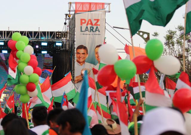 Supporters of Bolivia's presidential candidate for the Christian Democratic Party (PDC), Rodrigo Paz, wait for his speech during his closing campaign rally in Tarija, Bolivia, on October 15, 2025. An ex-president and a senator will go head-to-head in Bolivia's presidential runoff on October 19, 2025, both with promises to fix the South American country's broken economy. Senator Rodrigo Paz came from behind to take the top spot with 32 percent of votes cast in a first round in August, but has since fallen behind ex-president Jorge "Tuto" Quiroga in stated voter intention. (Photo by Marcelo GOMEZ / AFP)