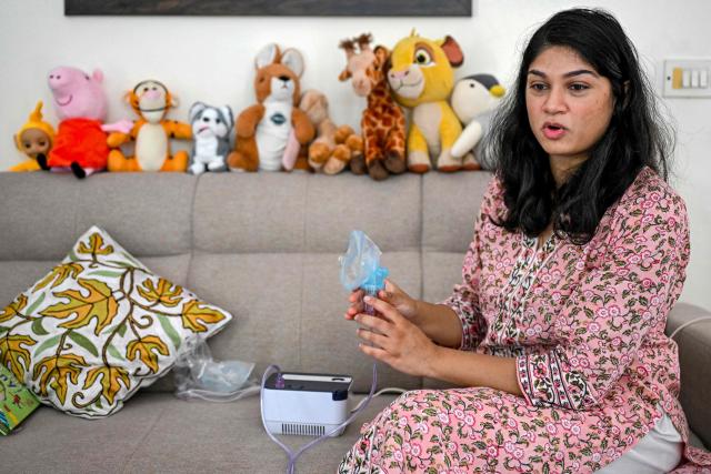 This photograph taken on October 2, 2025 shows Roli Shrivastava holding a nebulizer as she speaks during an interview with AFP at her residence in New Delhi. Pollution levels in India's capital city Delhi is shaping decisions on parenthood -- forcing a small yet growing number of people to flee because of the health hazards associated with toxic air. Home to more than 30 million people, New Delhi and the surrounding metropolitan area consistently tops world rankings for air pollution. (Photo by Sajjad HUSSAIN / AFP) / TO GO WITH 'India-Environment-Pollution-Health' FOCUS