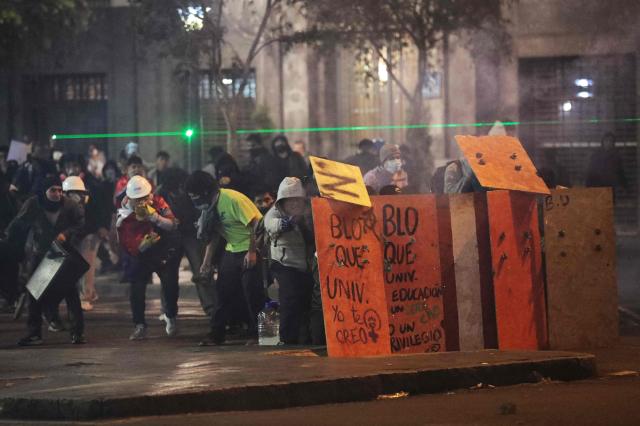 Demonstrators clash with anti-riot police officers during protest against Peru's interim President Jose Jeri in Lima on October 15, 2025.  (Photo by CONNIE FRANCE / AFP)
